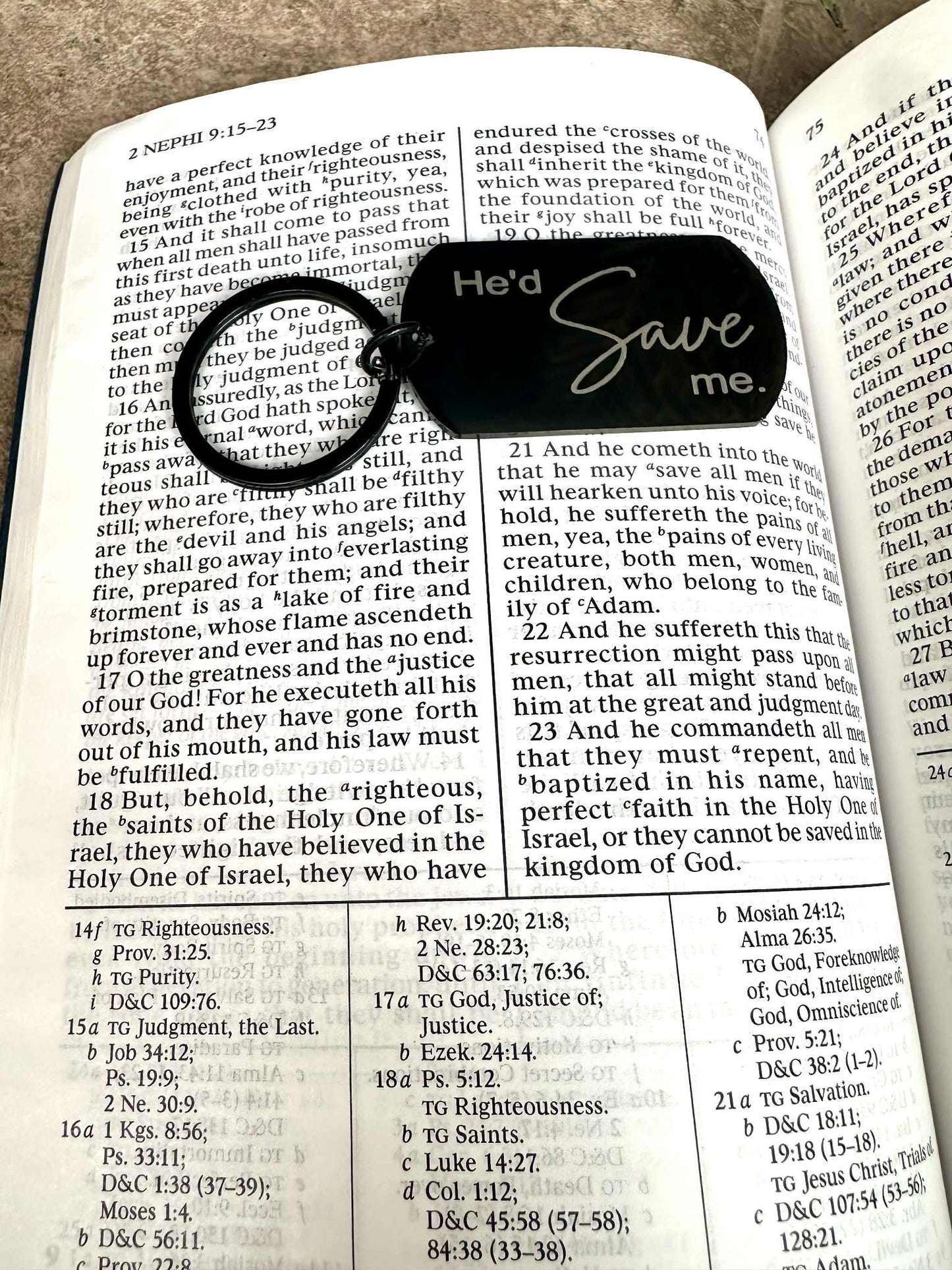 Black keychain with 'He'll Save Me' text on an open book of mormon