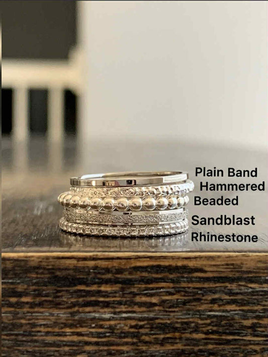 Stack of silver accent rings on a wooden surface with text labels.