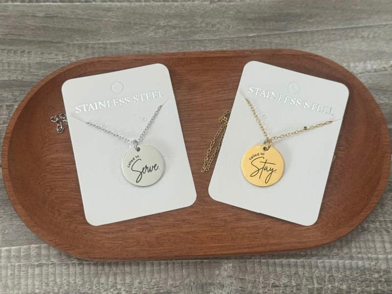 Two necklaces on cards on a wooden tray.