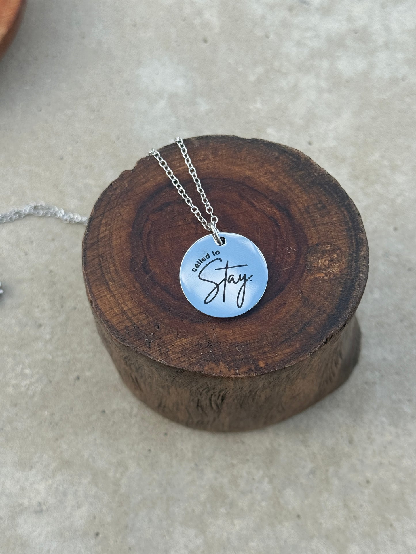 Necklace with a silver pendant on a wooden block